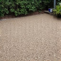 Before: Uneven and sparse gravel patio area in Green Valley requiring makeover. The image displays a residential patio area in Green Valley, AZ, with patchy, poorly distributed gravel and visible soil underneath.