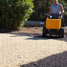 Decomposed granite spreading in progress during an Oro Valley project, showing workers evenly distributing material with rakes and machinery.