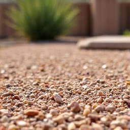 In progress view of gravel installation in Oro Valley, showing contractors preparing the ground, laying down weed barrier, and leveling the area.