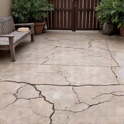 Deteriorated Gravel Driveway in Tucson. An old, uneven gravel driveway with weeds growing through and worn-out patches, indicating the necessity for professional gravel installation and repair services.