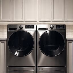 A team of professionals removing an old washing machine during an appliance removal service